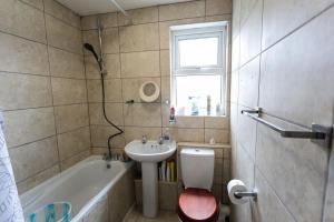 TownHouse4bedRoomHouse في West Dulwich: حمام مع حوض ومرحاض وحوض استحمام
