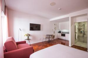 里斯本Lisbon Serviced Apartments - Campos的客厅里有一张红色的沙发和一张桌子