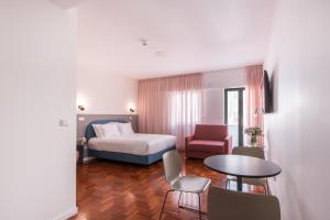 里斯本Lisbon Serviced Apartments - Campos的一间带床、桌椅的酒店房间