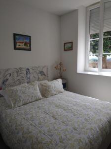 a bedroom with a bed and two windows at Chambres d'Hôtes La Courlande in Saint-Haon-le-Vieux