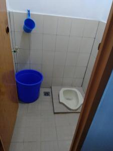 a bathroom with a toilet and a blue bucket at Pondok Pusaka Alam 2 Pangandaran in Pangandaran
