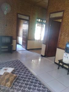 une chambre avec deux portes et un tapis au sol dans l'établissement Pondok Pusaka Alam 2 Pangandaran, à Pangandaran