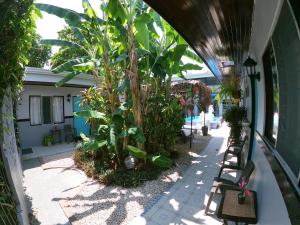 a building with a bunch of plants in a courtyard at Hotel Perico Azul & Surf Camp in Jacó