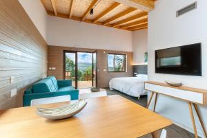 LinaresにあるCieloAstur Complejo Turísticoのベッド、テレビ、テーブルが備わる客室です。
