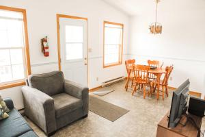 - un salon avec un canapé et une table dans l'établissement Peck's Housekeeping Cottages, à Louisbourg