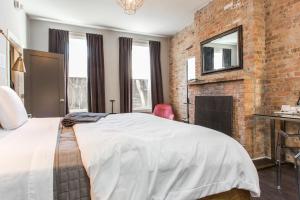 a brick walled bedroom with a bed and a fireplace at Wicker Park Inn in Chicago