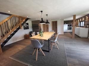 Una cocina y un comedor con mesa y sillas de madera. en Kräuterhof Chalets, en Missen-Wilhams