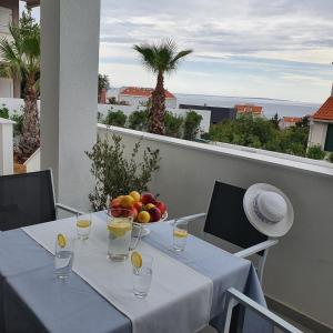 una mesa con un bol de fruta en el balcón en Villa Aquamarine Apartments en Novalja