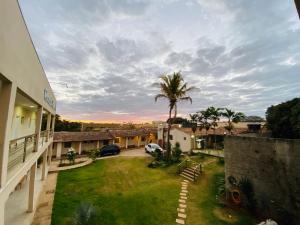 a view of a yard with a palm tree at Hotel Pousada Marra in Catalão