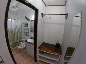 a bathroom with a toilet and a sink and a mirror at Hotel Perico Azul & Surf Camp in Jacó