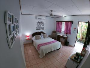 a bedroom with a bed and a table with a lamp at Hotel Perico Azul & Surf Camp in Jacó