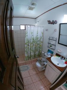 a bathroom with a sink and a toilet and a shower at Hotel Perico Azul & Surf Camp in Jacó