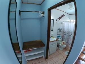 a bathroom with a shower and a toilet and a mirror at Hotel Perico Azul & Surf Camp in Jacó