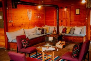 Kuşpuni Mountain Lodge في آيدر يايلاسِه: غرفة معيشة مع أريكة وكراسي وطاولة
