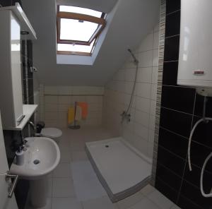 a bathroom with a sink and a bath tub and a window at BC Apartments in Niš