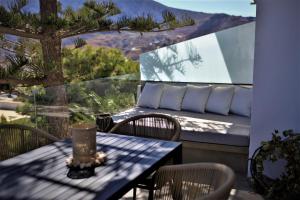 d'une table et de chaises sur un balcon avec vue. dans l'établissement A Lux Villas Santorini, à Éxo Goniá