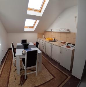 a kitchen with a table and chairs and a kitchen with windows at BC Apartments in Niš