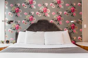 a bedroom with a bed with pink flowers on a wall at Wicker Park Inn in Chicago