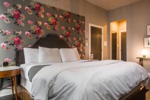 een slaapkamer met een groot bed met bloemen aan de muur bij Wicker Park Inn in Chicago