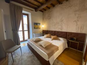 a bedroom with a white bed and white walls at Rhona's Rooms in Rome