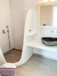 a bathroom with a sink and a toilet and a mirror at The Cliff Reflections - Adults Only in Megalochori