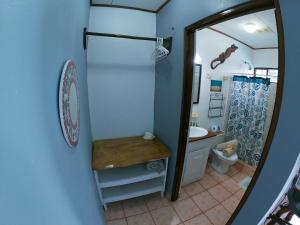 a bathroom with a sink and a toilet and a mirror at Hotel Perico Azul & Surf Camp in Jacó