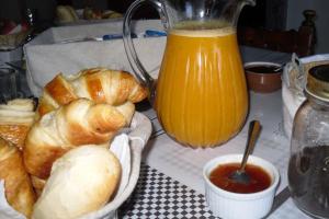 Chambre d'Hôtes La Marlotte في Castello-di-Rostino: طاولة مع الخبز وإبريق من عصير البرتقال
