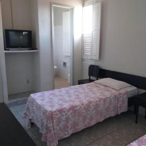 Dormitorio pequeño con cama y TV en Hotel Central, en Recife