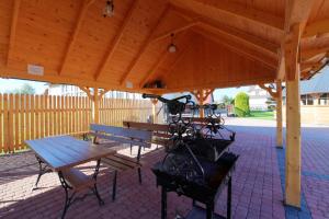 a wooden pavilion with benches and a picnic table at Dom Wczasowy Dunajec in Biały Dunajec