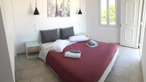 een slaapkamer met een groot bed en handdoeken bij Evagelia's Place in Agios Ioannis Mykonos
