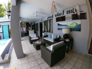 a salon with couches and chairs and a pool at Hotel Perico Azul & Surf Camp in Jacó