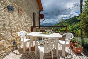 einen weißen Tisch und Stühle auf einer Terrasse in der Unterkunft Casa La Palombara in Rosciolo