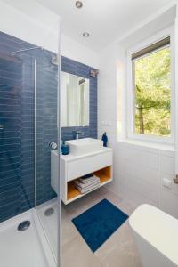 a bathroom with a sink and a glass shower at Orkana 13 Apartments in Zakopane