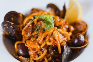 a plate of food with pasta and mushrooms at Hotel San Andrea in Xlendi