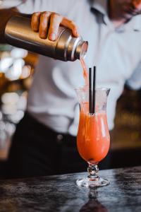 a person pouring a drink into a glass at Hotel San Andrea in Xlendi