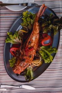 a plate of food with fish and salad on a table at Hotel San Andrea in Xlendi
