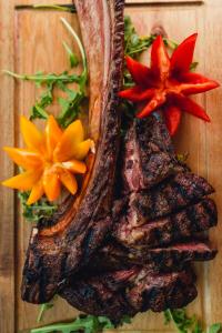 a steak on a cutting board with flowers on it at Hotel San Andrea in Xlendi