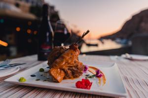 a white plate with food on a table at Hotel San Andrea in Xlendi