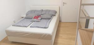 a white bed with pillows on it in a room at Love 2 Solkan in Nova Gorica