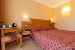 a hotel room with a bed and a telephone at Hotel San Andrea in Xlendi