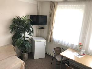 un soggiorno con un divano, un tavolo e una TV di Pension Crhan a Mikulov