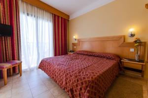 a hotel room with a bed and a window at Hotel San Andrea in Xlendi