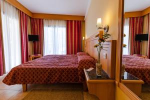 Pokój hotelowy z 2 łóżkami i lustrem w obiekcie Hotel San Andrea w mieście Xlendi