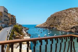 a view of a harbor with boats in the water at Hotel San Andrea in Xlendi