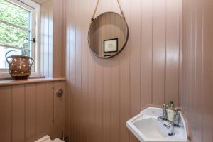 a bathroom with a sink and a mirror at Owl Cottage in Wighton