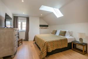a bedroom with a bed and a skylight at Owl Cottage in Wighton