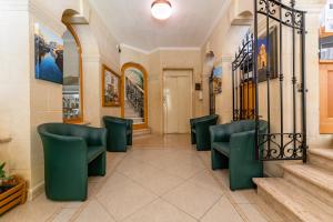 a waiting room with green chairs and stairs at Hotel San Andrea in Xlendi