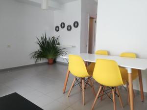 comedor con mesa y sillas amarillas en Franja de Mar - Duplex amplio y luminoso en Santa Cruz de la Palma