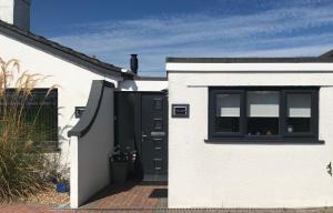a white house with a black door and a window at Kiki’s Corner in Newquay