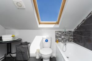 a bathroom with a toilet and a bath tub at Stopover at ORCHARD LOFT, cosy and convenient in Portsmouth